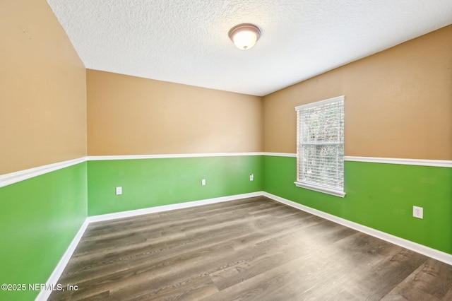 empty room with wood-type flooring and a textured ceiling