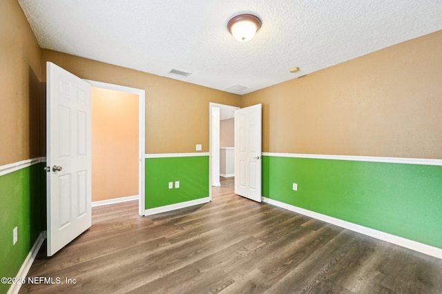 unfurnished bedroom with wood-type flooring and a textured ceiling