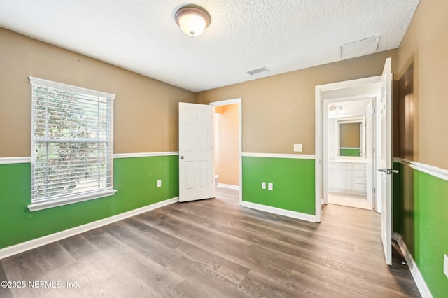 unfurnished bedroom featuring wood-type flooring and a textured ceiling