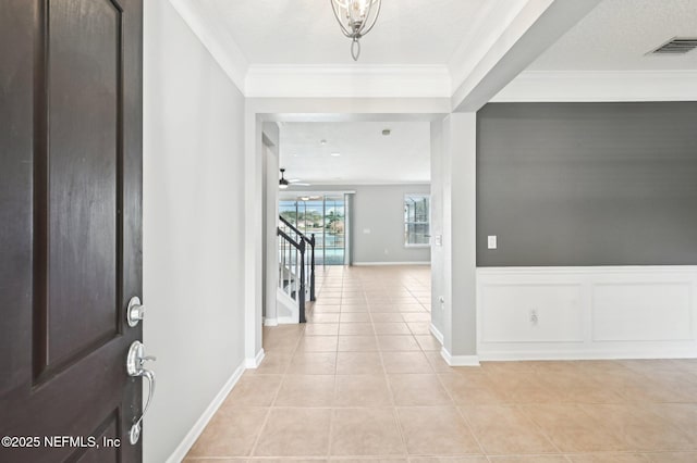 tiled entrance foyer featuring ornamental molding and a textured ceiling