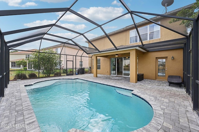 view of pool with a patio and glass enclosure