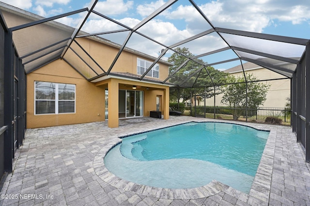 view of pool featuring a patio area, ceiling fan, and glass enclosure