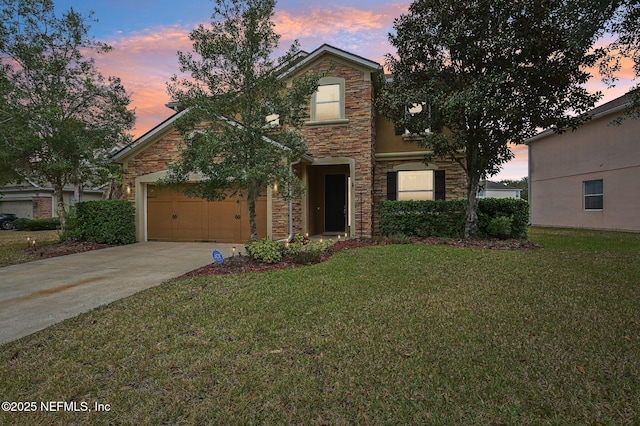 front facade featuring a garage and a yard