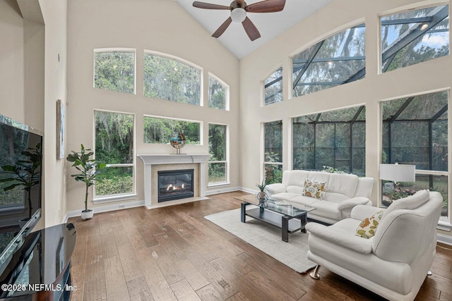 living room featuring a high ceiling, dark hardwood / wood-style flooring, and a healthy amount of sunlight