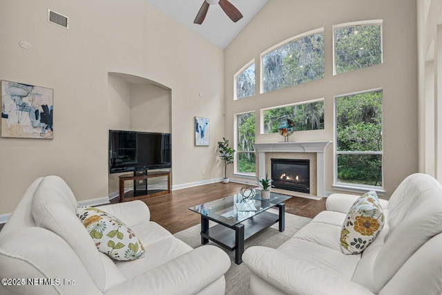 living room with high vaulted ceiling, a healthy amount of sunlight, and hardwood / wood-style floors