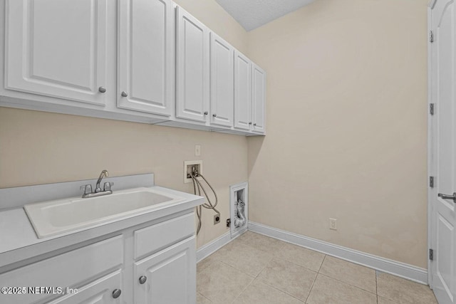 laundry area with sink, hookup for a washing machine, light tile patterned floors, cabinets, and a textured ceiling