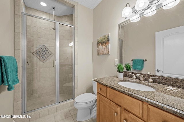 bathroom featuring tile patterned floors, a textured ceiling, toilet, walk in shower, and vanity