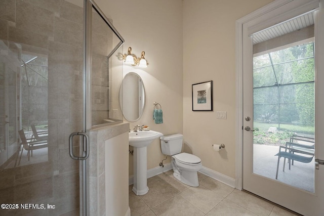 bathroom featuring sink, toilet, tile patterned flooring, and an enclosed shower