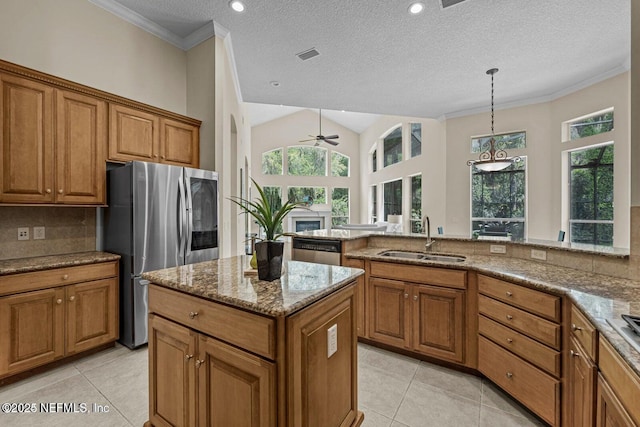 kitchen featuring light stone countertops, sink, a textured ceiling, and appliances with stainless steel finishes