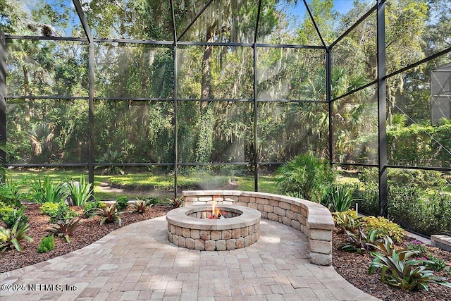 view of patio featuring an outdoor fire pit and a lanai