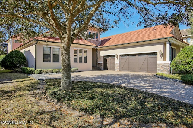 mediterranean / spanish house with a garage and a front lawn