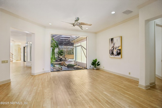 empty room with ornamental molding, ceiling fan, and light wood-type flooring