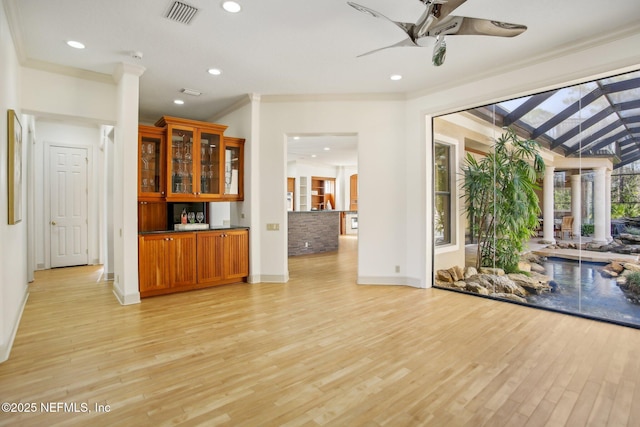 unfurnished living room with crown molding, light hardwood / wood-style flooring, and ceiling fan