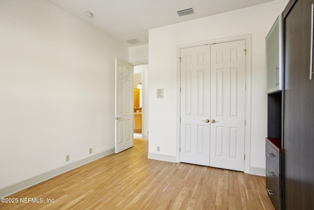 unfurnished bedroom with a closet and light wood-type flooring