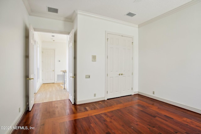 unfurnished bedroom with wood-type flooring, ornamental molding, and a closet