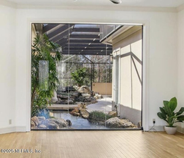 doorway to outside featuring crown molding and hardwood / wood-style floors