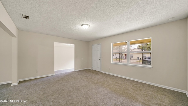 carpeted spare room featuring a textured ceiling