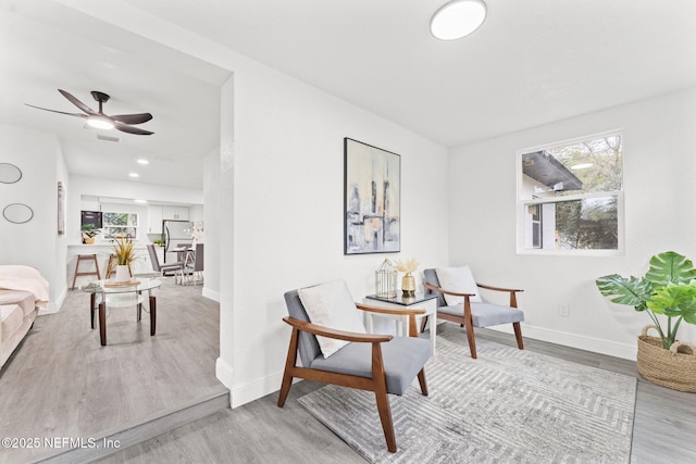 sitting room with plenty of natural light, light hardwood / wood-style flooring, and ceiling fan