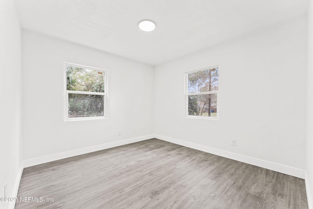 unfurnished room with hardwood / wood-style flooring