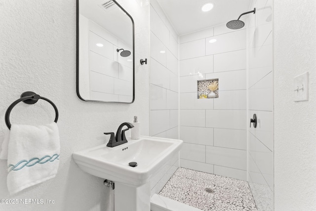 bathroom featuring sink and tiled shower