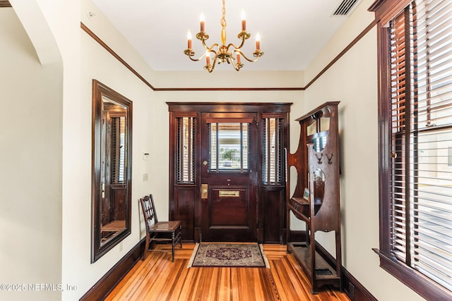 foyer entrance featuring hardwood / wood-style flooring and a notable chandelier