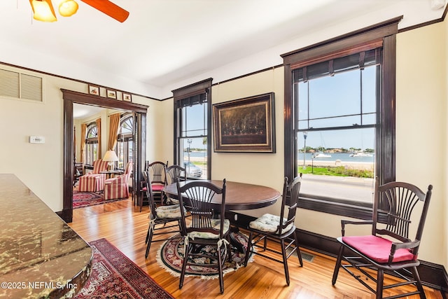 dining space with light hardwood / wood-style floors and ceiling fan