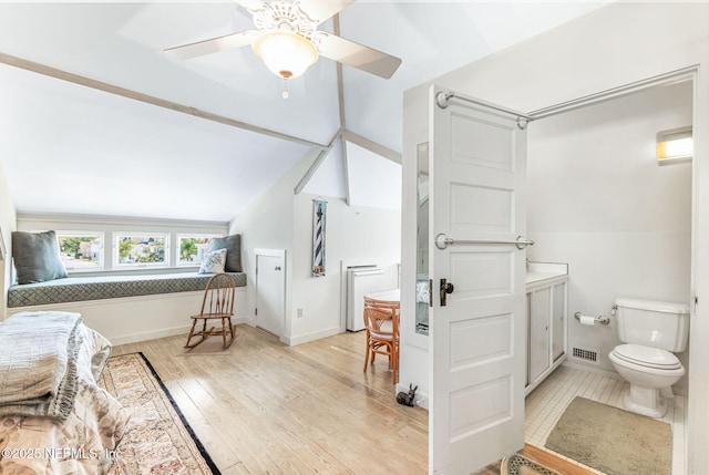 bathroom featuring ceiling fan, hardwood / wood-style floors, and lofted ceiling