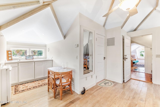 foyer entrance with a healthy amount of sunlight, light hardwood / wood-style floors, and lofted ceiling