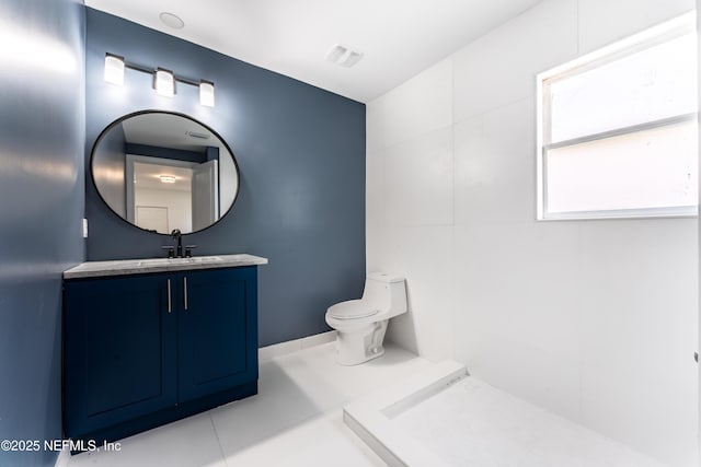 bathroom featuring toilet, vanity, and tile patterned flooring