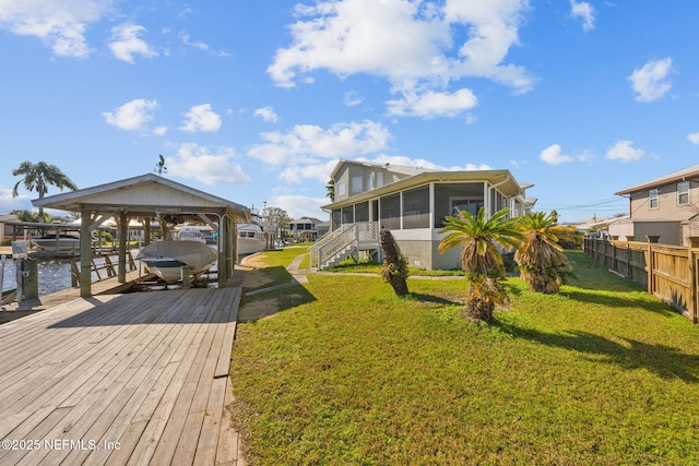 exterior space with a water view, a sunroom, and a lawn