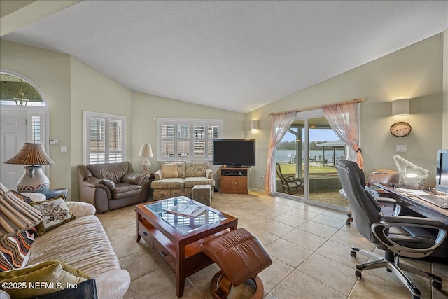 living room featuring vaulted ceiling, light tile patterned floors, and a textured ceiling