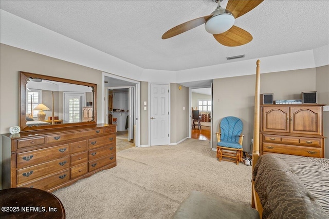 carpeted bedroom with ceiling fan and a textured ceiling