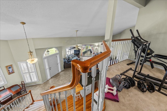 staircase featuring lofted ceiling and a textured ceiling