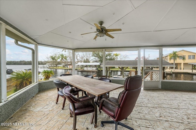 sunroom featuring a water view and ceiling fan