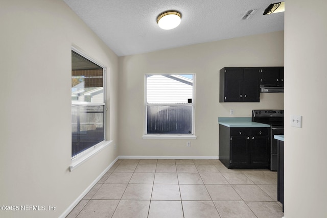 kitchen with a textured ceiling, light tile patterned floors, black range with electric stovetop, and lofted ceiling