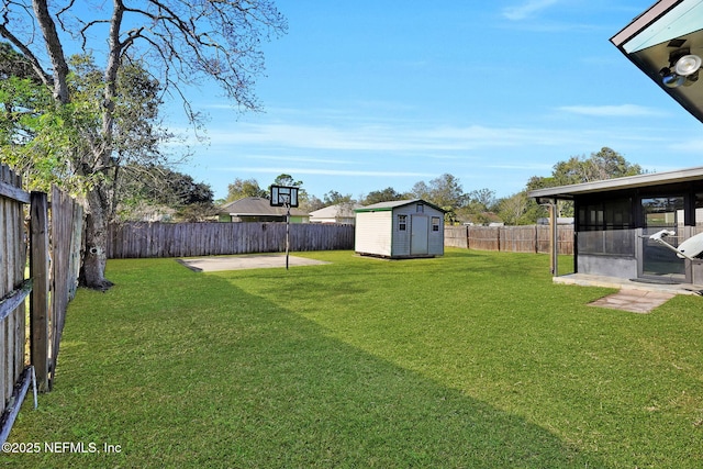 view of yard featuring a sunroom, a patio area, and a shed