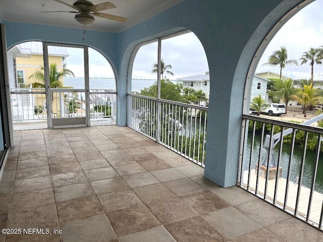 exterior space with ceiling fan and a water view