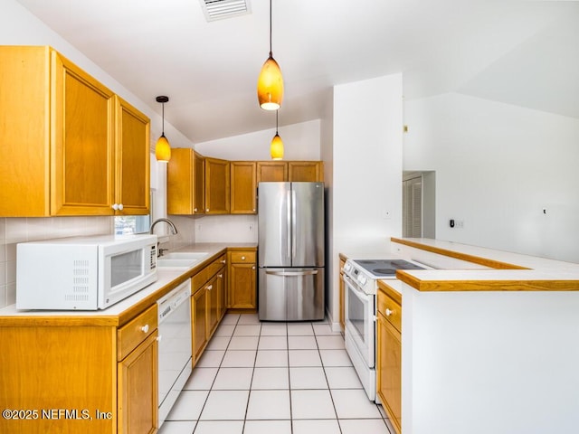 kitchen with sink, white appliances, lofted ceiling, and hanging light fixtures