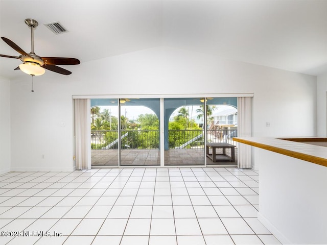 tiled empty room with ceiling fan and vaulted ceiling