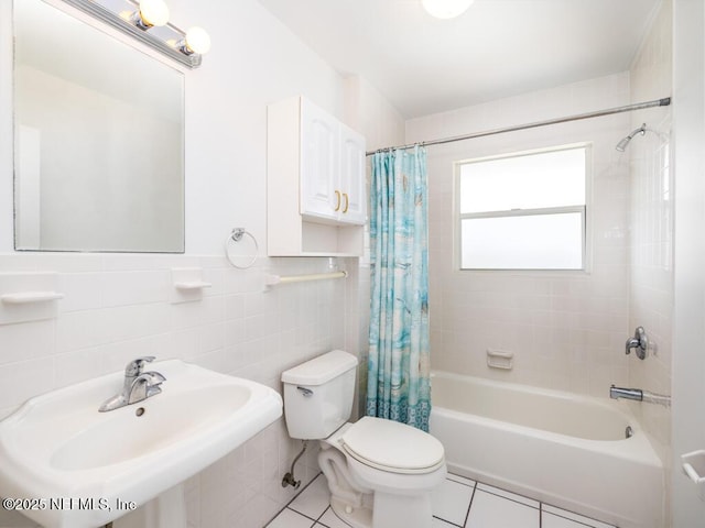 full bathroom with shower / bathtub combination with curtain, tile patterned floors, sink, tile walls, and toilet