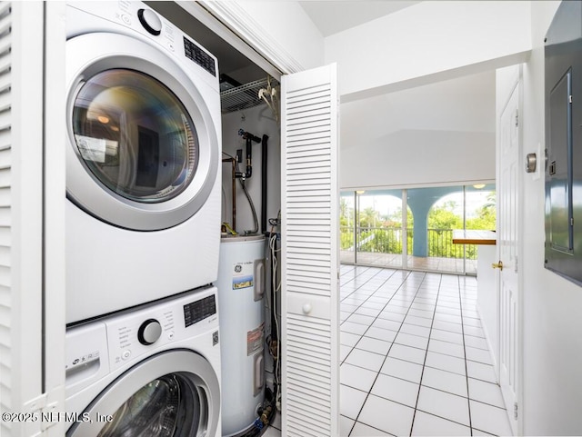 washroom featuring light tile patterned floors, stacked washing maching and dryer, and water heater