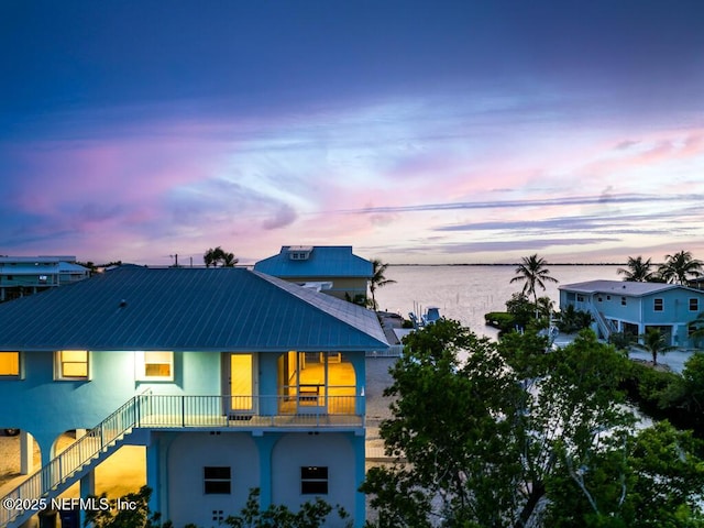 exterior space featuring a balcony and a water view