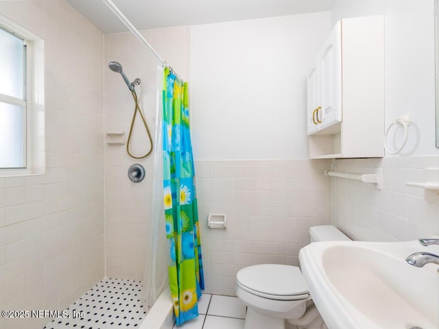 bathroom featuring a shower with curtain, sink, tile patterned flooring, and tile walls