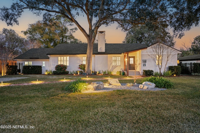 ranch-style home featuring a lawn