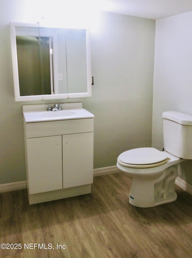 bathroom featuring hardwood / wood-style flooring, toilet, and vanity