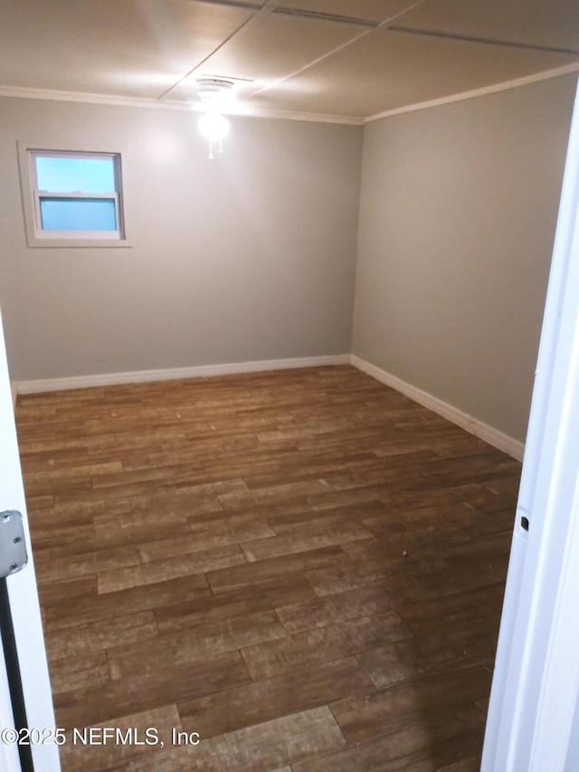 empty room with ceiling fan, crown molding, and dark wood-type flooring