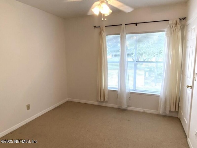 carpeted spare room featuring ceiling fan