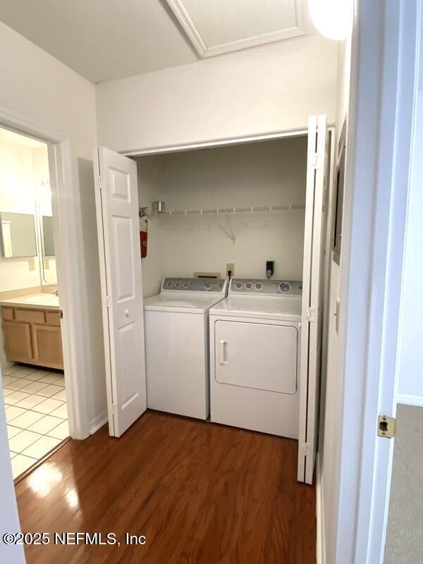 washroom featuring dark wood-type flooring, sink, and washer and dryer