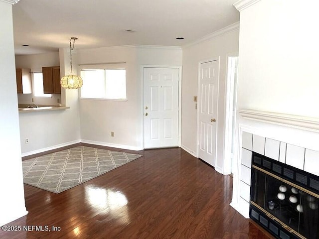 unfurnished living room with dark wood-type flooring, a fireplace, and crown molding