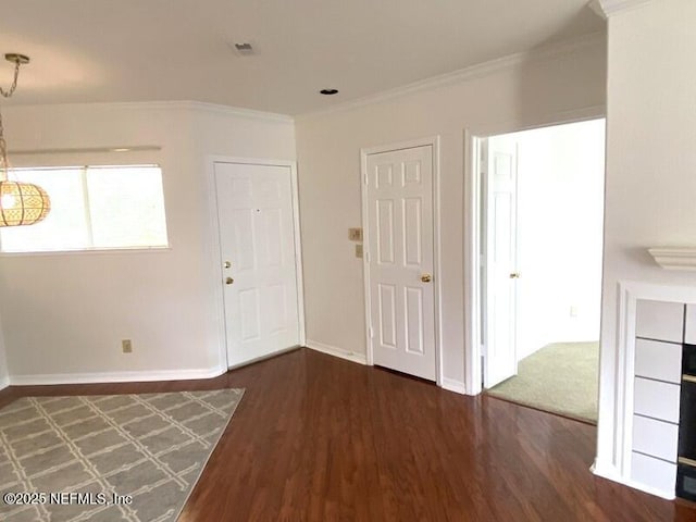 spare room featuring crown molding and dark hardwood / wood-style floors